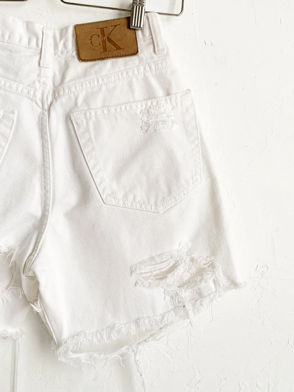 CK Distressed White Cut Offs