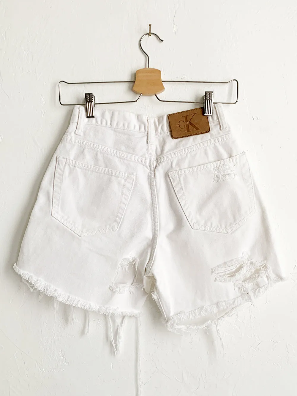 CK Distressed White Cut Offs